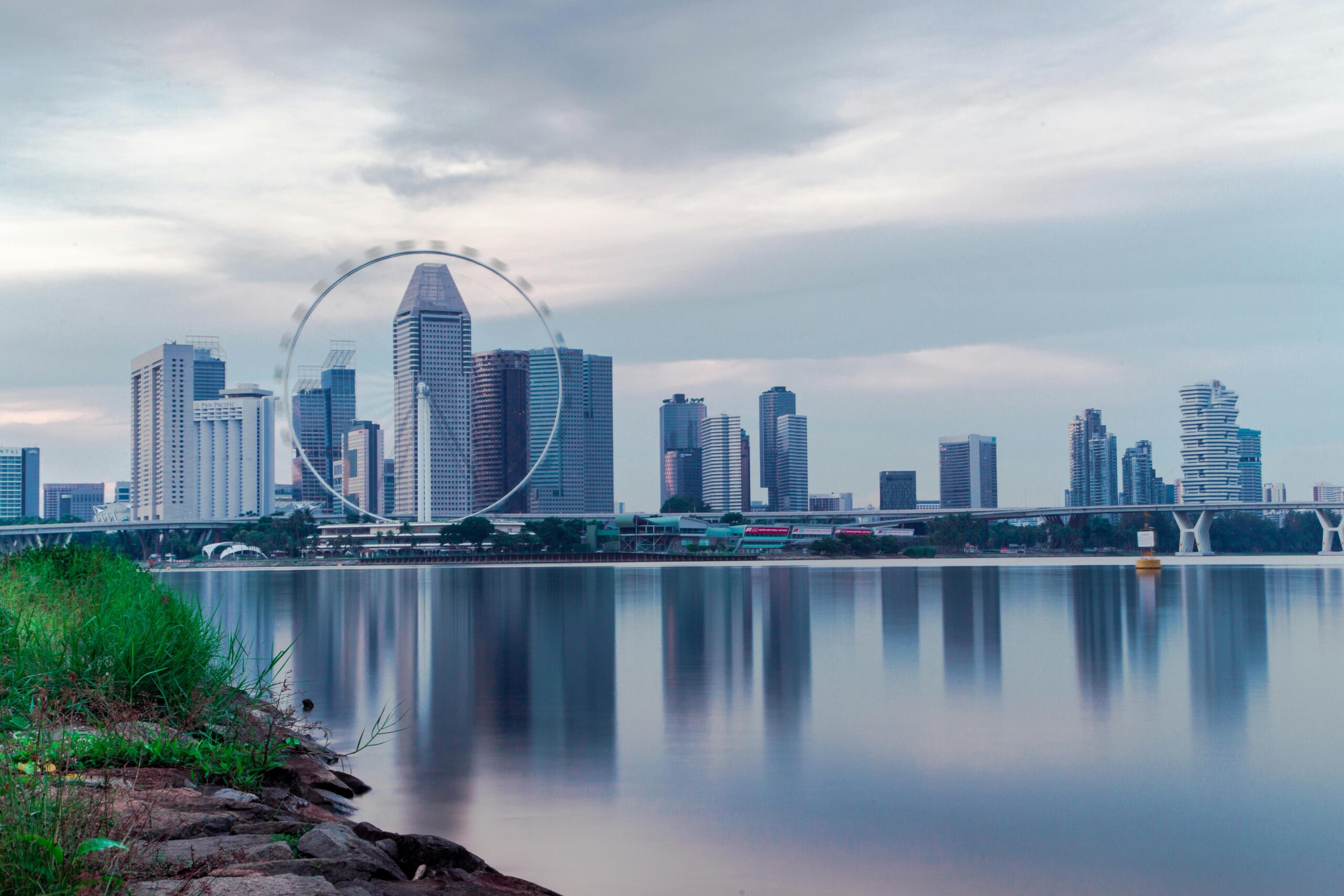 Captivating view of Singapore's skyline featuring the iconic Singapore Flyer reflecting over calm waters.