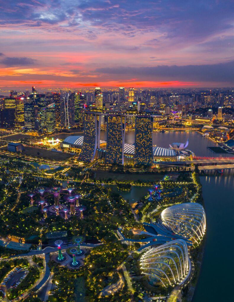 Stunning aerial view of Singapore skyline with Marina Bay Sands and Gardens by the Bay at twilight.
