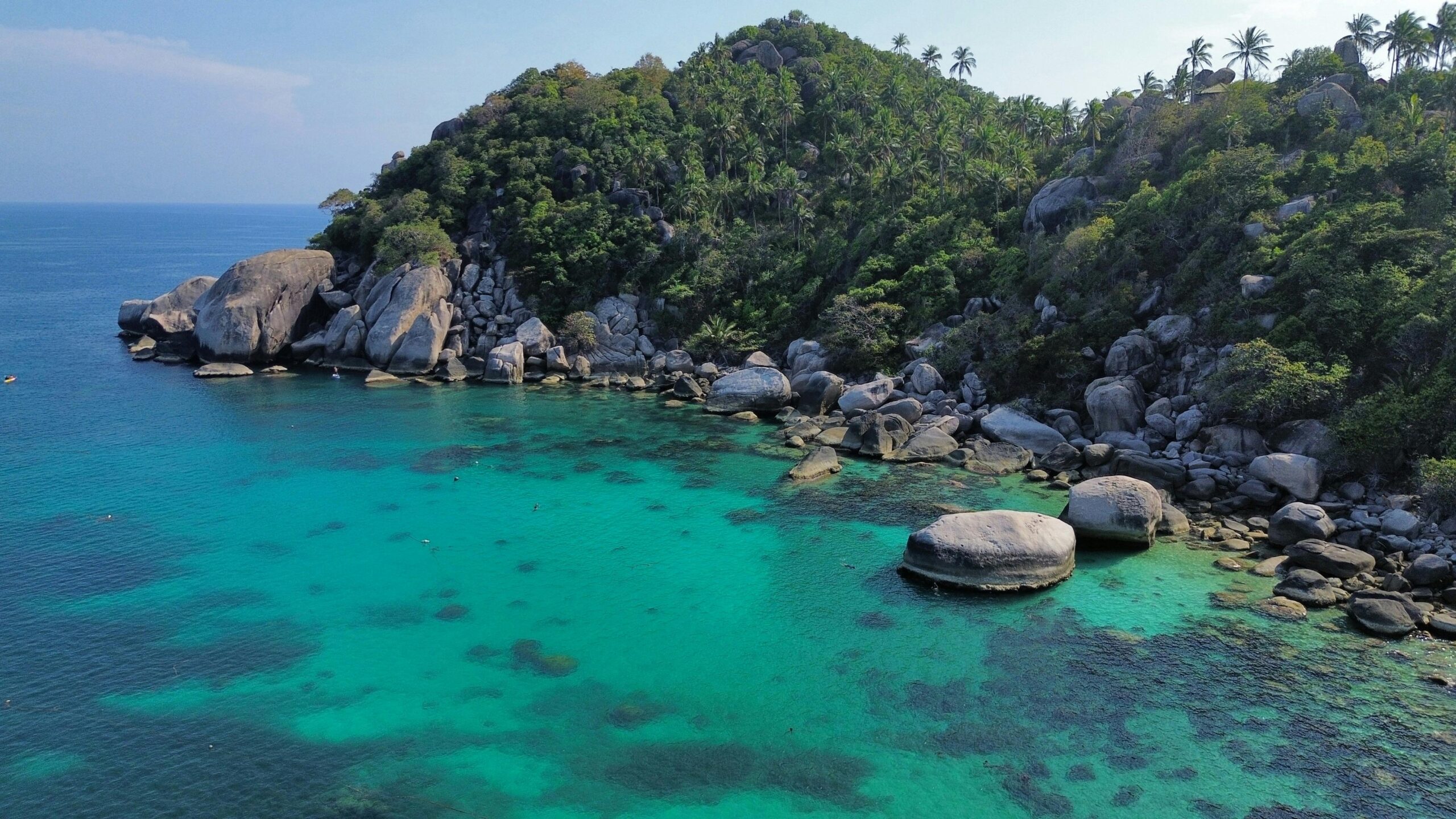 Aerial shot of the stunning tropical Shark Bay with turquoise waters and lush greenery in Koh Tao, Thailand.
