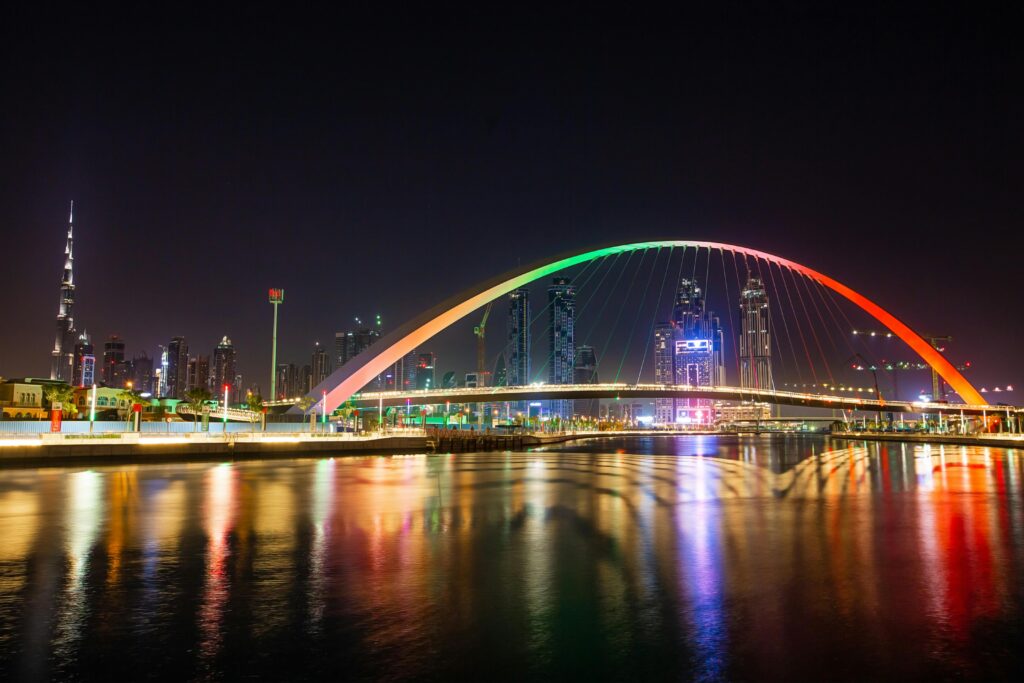 Stunning view of Dubai's Tolerance Bridge and Burj Khalifa skyline illuminated at night.